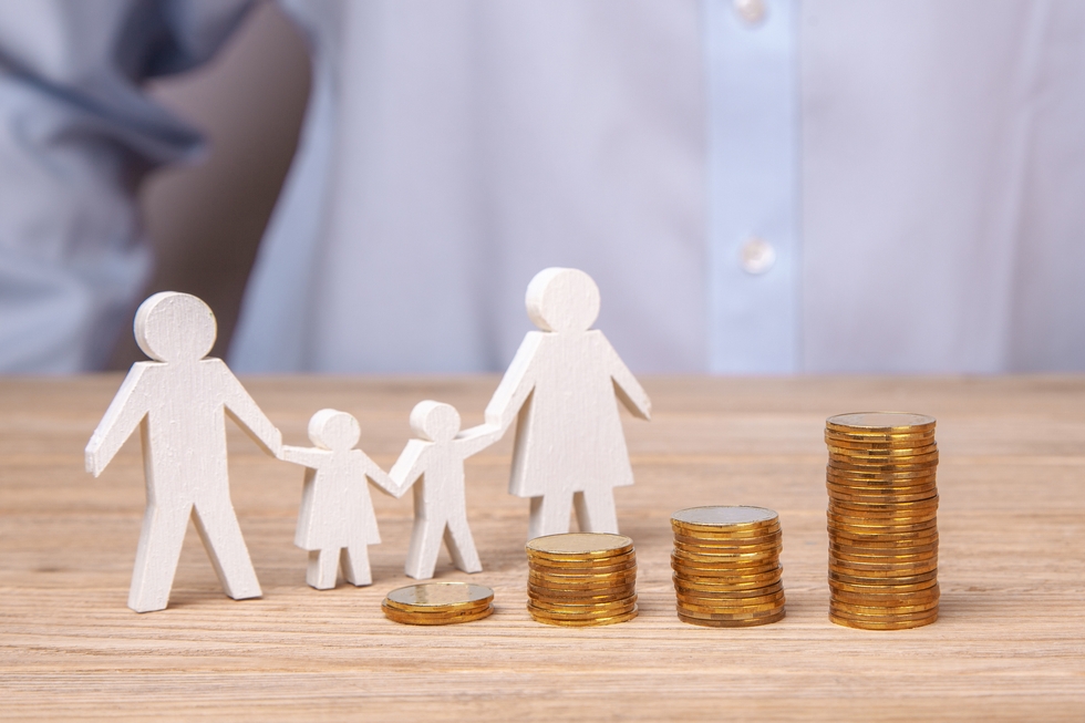 Growth of the family budget. Man holds family from his father, mother, daughter and son against the background of stack of coins
