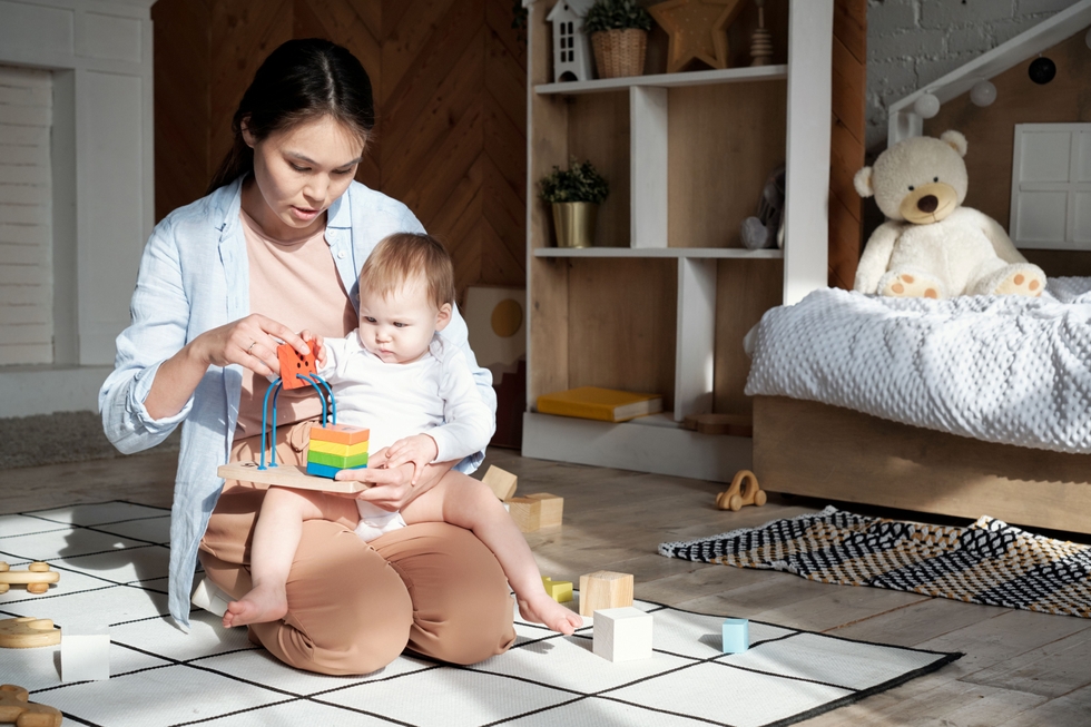 Modern_Mother_And_Child_Playing_With_Toy_At_Home_original_3486298.jpg