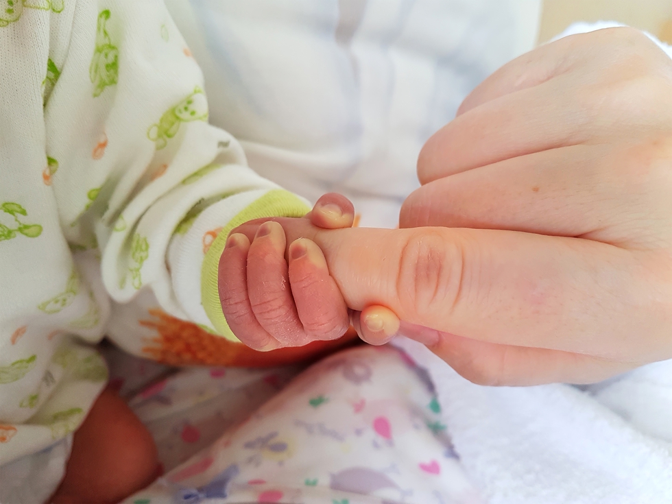 Baby hand wrapped around finger