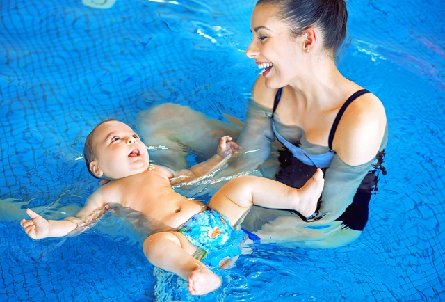 Young mother and baby relaxing in the swimming pool